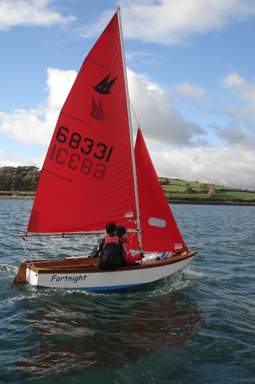 Mirror dinghy 68331 sailing upwind in a gentle/moderate breeze with blue sky and sunshine